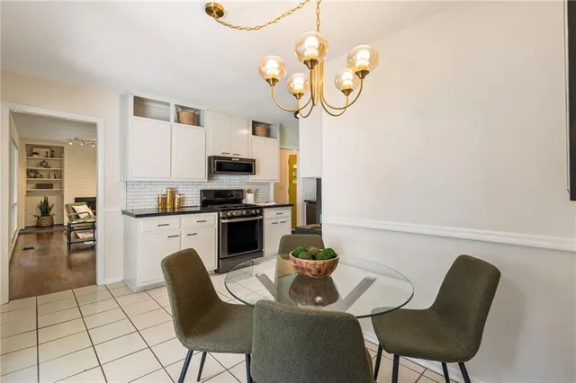 a kitchen with a dining table chairs stainless steel appliances and cabinets