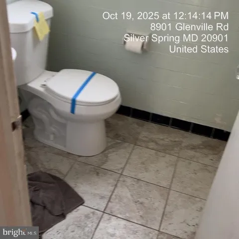 a white toilet sitting next to a white wall