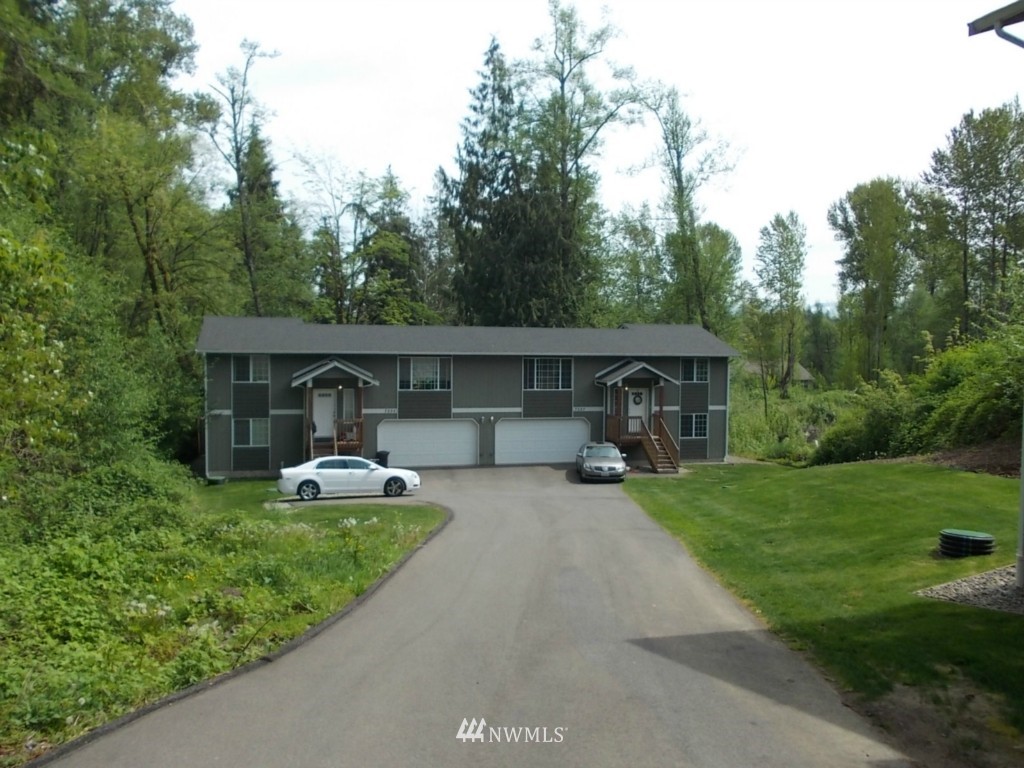 7235 Vandermark Road East Bonney Lake, WA 98391 - Photo 1 of 11 a front view of a house with a garden and trees