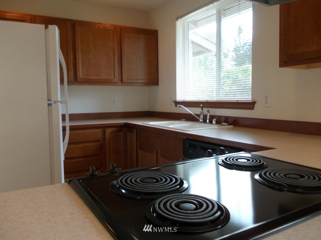 7235 Vandermark Road East Bonney Lake, WA 98391 - Photo 3 of 11 a kitchen with a stove and a sink