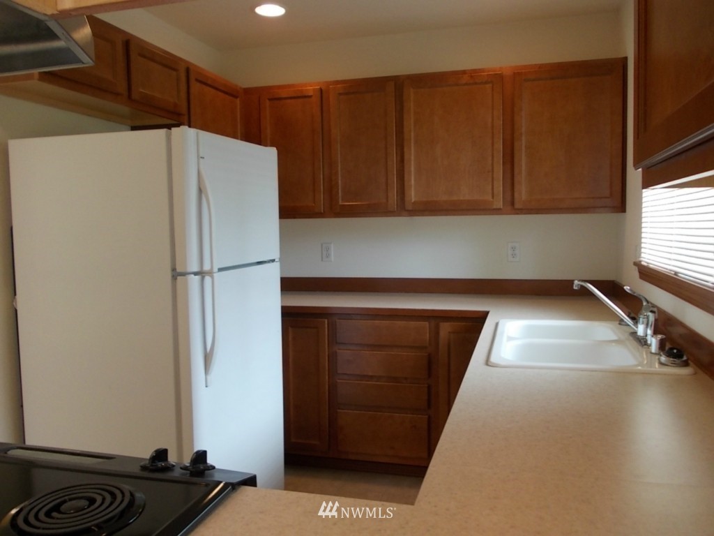 7235 Vandermark Road East Bonney Lake, WA 98391 - Photo 4 of 11 a kitchen with a refrigerator and a sink