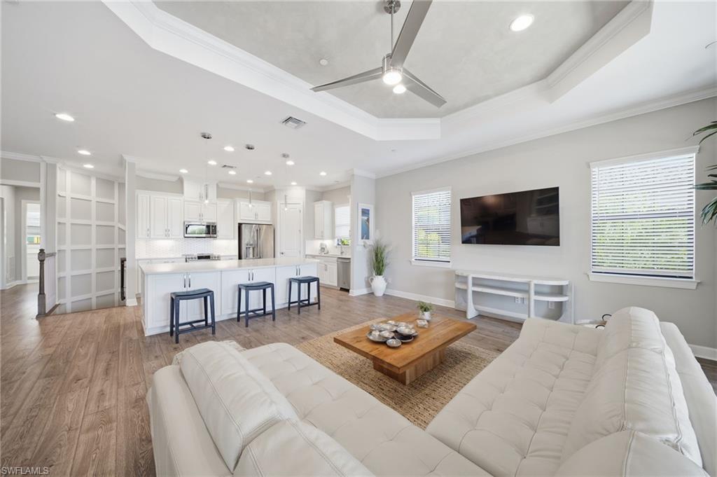 9658 Montelanico Loop, Unit 201 Naples, FL 34119 - Photo 11 of 46 a living room with furniture a flat screen tv and kitchen view