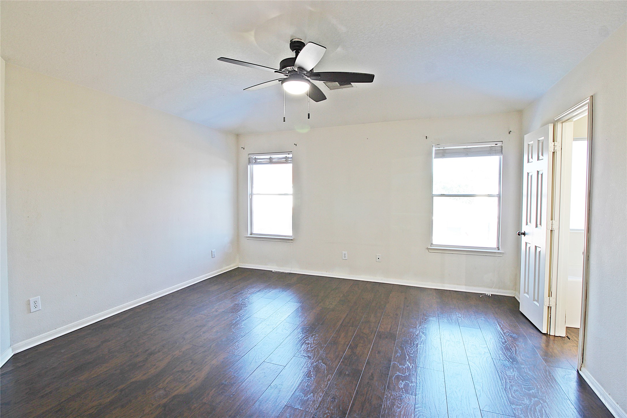 8314 Silver Fir Lane Baytown, TX 77523 - Photo 12 of 22 an empty room with wooden floor fan and windows