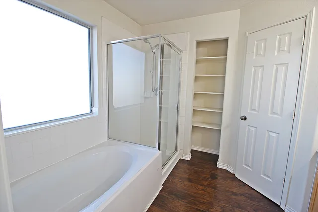 a view of bathroom with bathtub and wooden floor