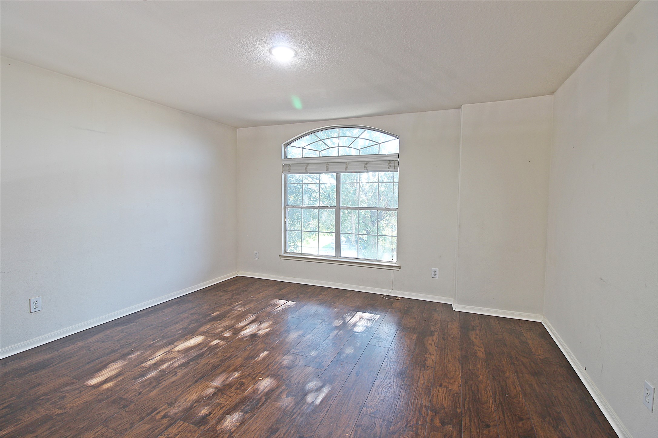8314 Silver Fir Lane Baytown, TX 77523 - Photo 15 of 22 an empty room with wooden floor and windows