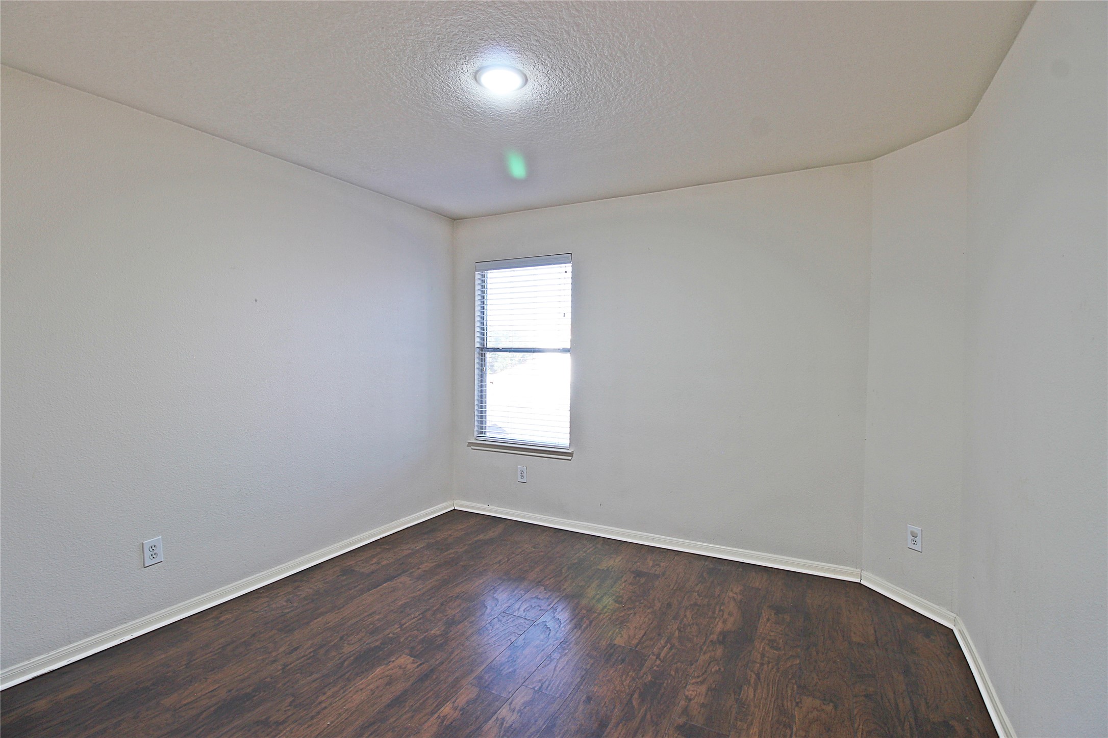 8314 Silver Fir Lane Baytown, TX 77523 - Photo 18 of 22 an empty room with wooden floor and windows
