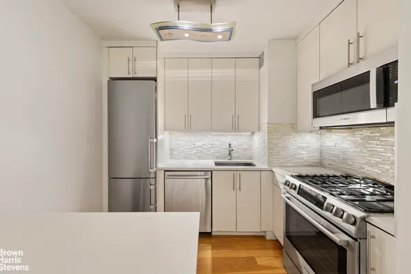 a kitchen with stainless steel appliances a refrigerator a stove top oven and sink