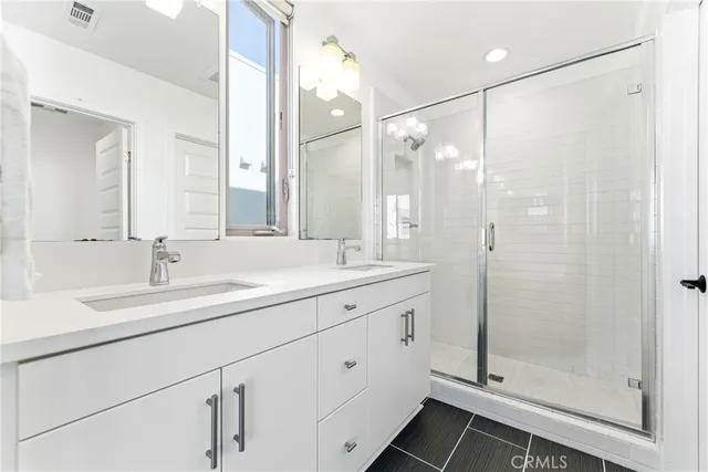 a bathroom with a shower sink and mirror