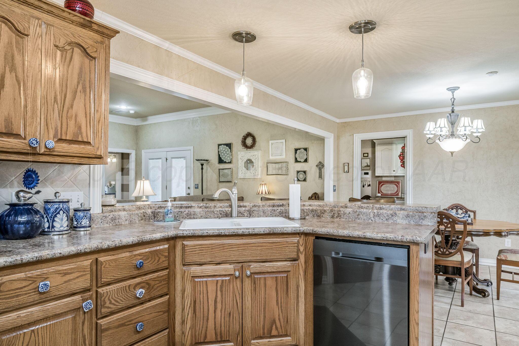 6007 Hunter Drive Amarillo, TX 79119 - Photo 13 of 28 a kitchen with granite countertop a sink cabinets and wooden floor
