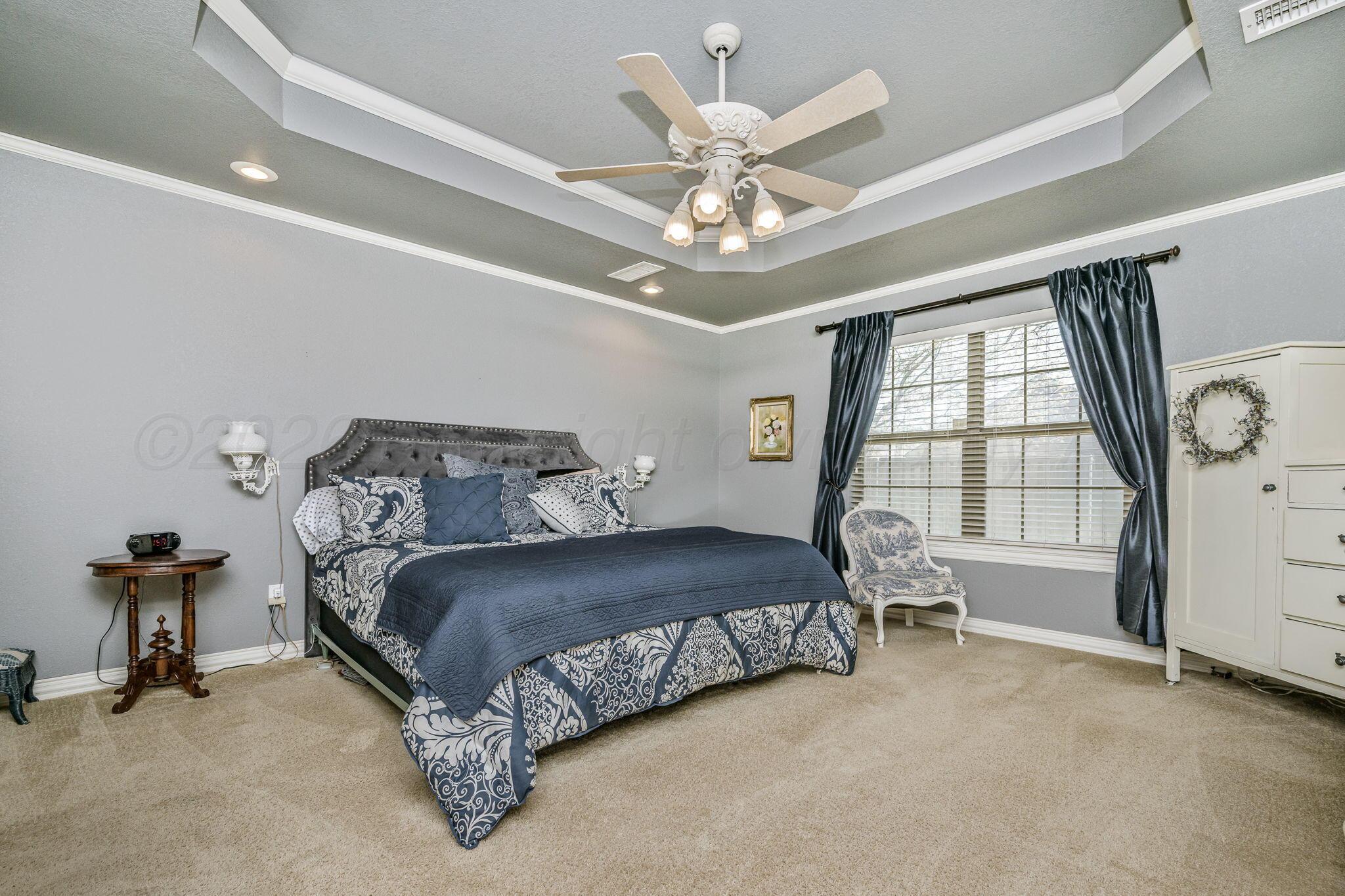 6007 Hunter Drive Amarillo, TX 79119 - Photo 15 of 28 a bedroom with a bed and a chandelier