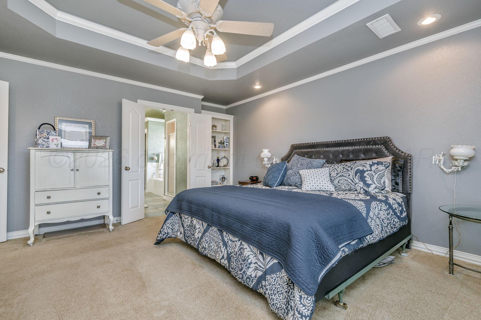 6007 Hunter Drive Amarillo, TX 79119 - Photo 16 of 28 a bedroom with a bed and a chandelier