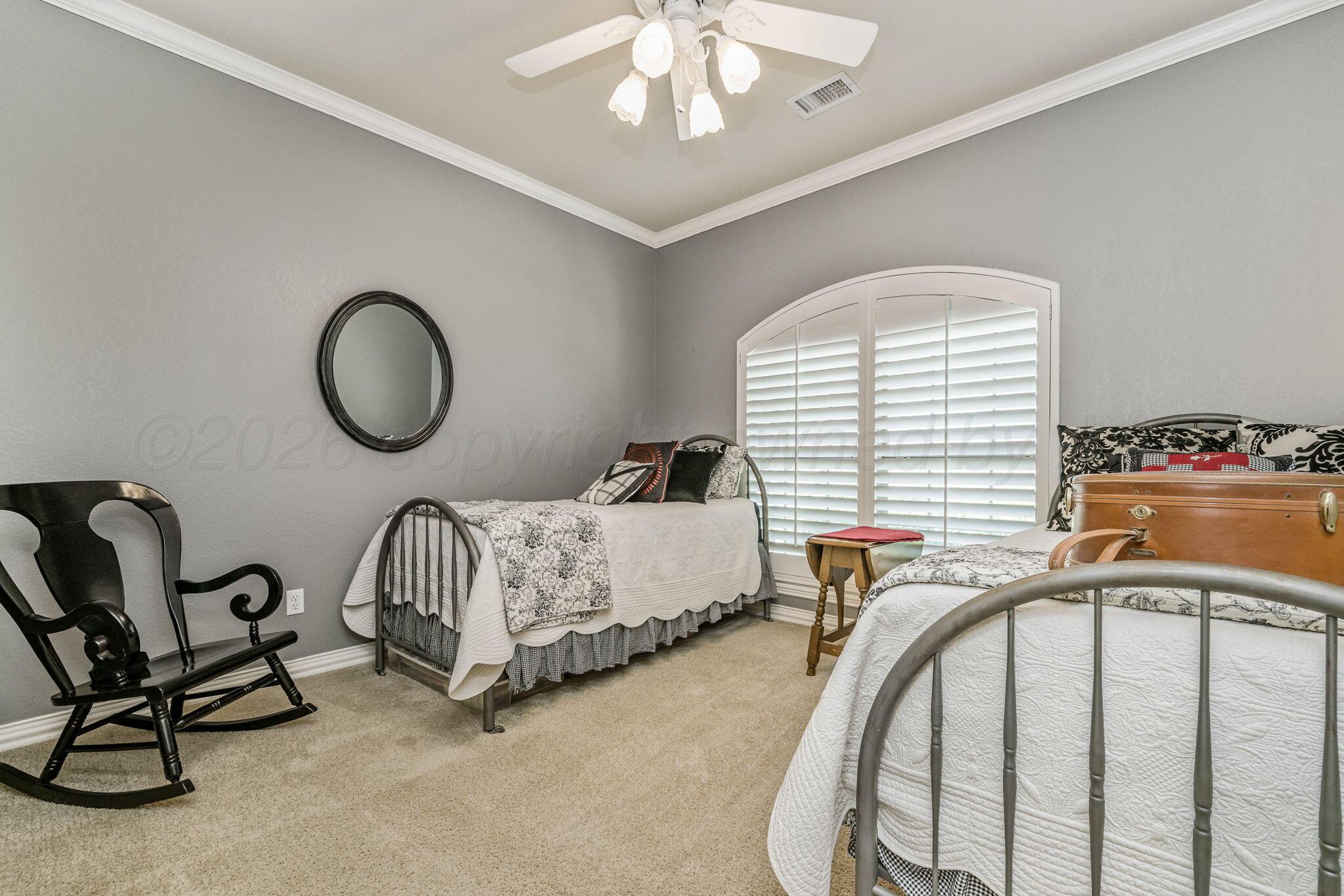 6007 Hunter Drive Amarillo, TX 79119 - Photo 19 of 28 a bedroom with bed and a chandelier