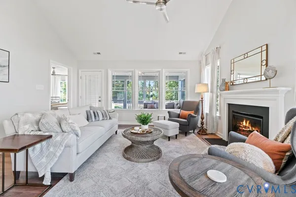 a living room with furniture a fireplace and a large window