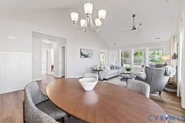 a living room with furniture a chandelier fan and a dining table