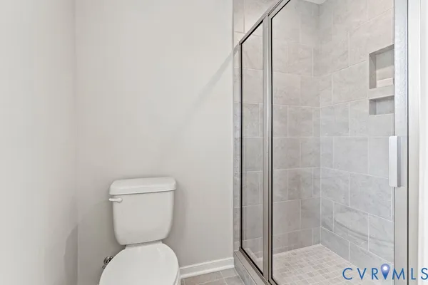 a white toilet sitting next to a shower