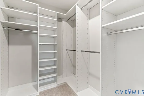 a view of walk in closet with empty racks