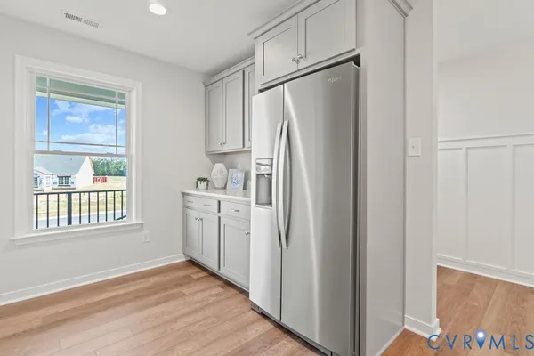 a kitchen with white cabinets and refrigerator
