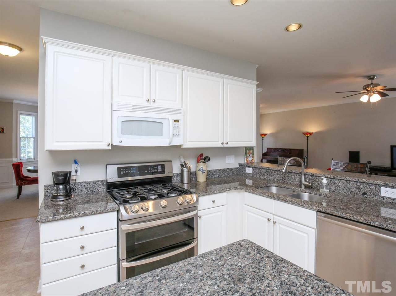 2329 Finley Ridge Lane Raleigh, NC 27615 - Photo 13 of 27 a kitchen with granite countertop white cabinets and stainless steel appliances