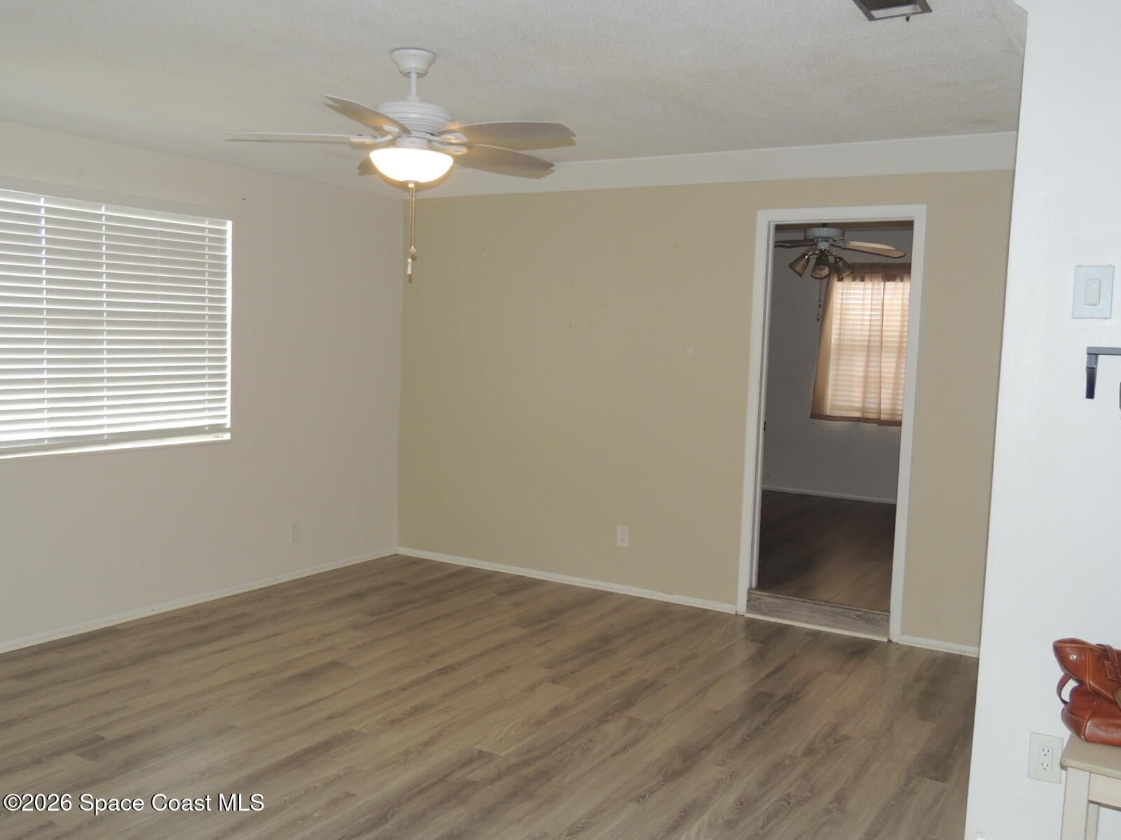 1312 Huntington Lane Rockledge, FL 32955 - Photo 4 of 21 a view of an empty room with wooden floor and a window
