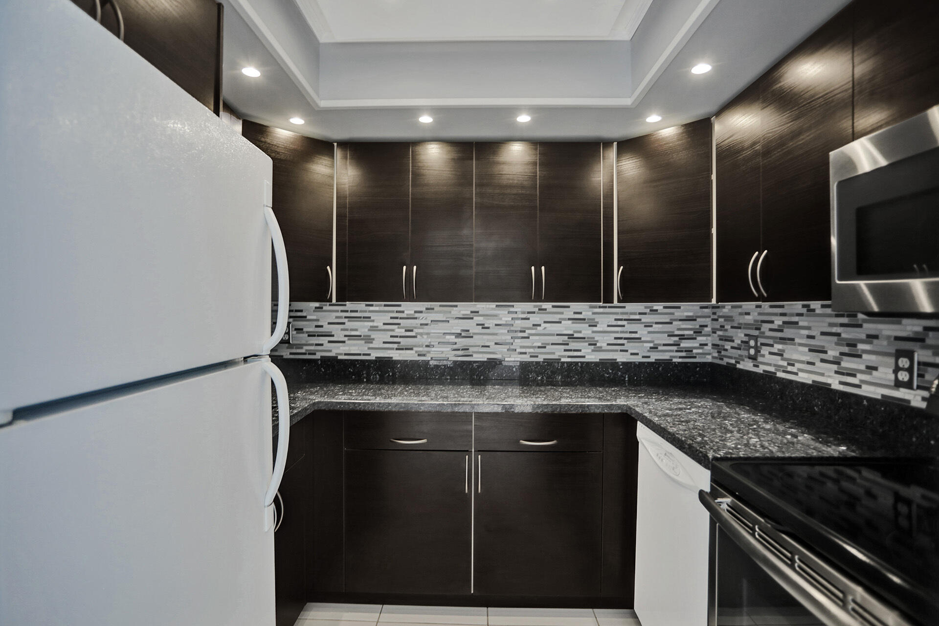 111 Briny Avenue, Unit 810 Pompano Beach, FL 33062 - Photo 12 of 62 a bathroom with a granite countertop sink a toilet and a mirror