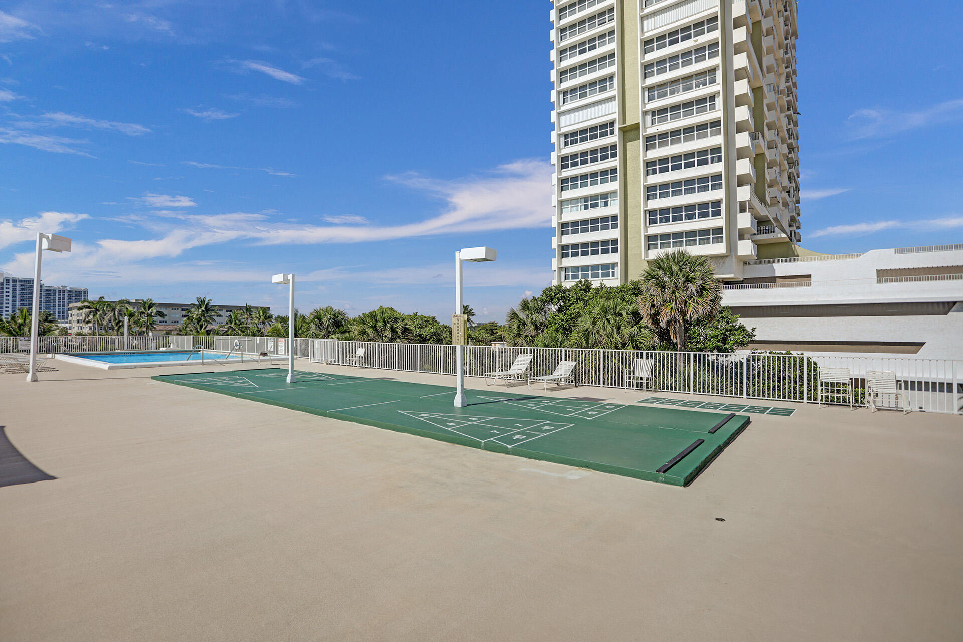 111 Briny Avenue, Unit 810 Pompano Beach, FL 33062 - Photo 52 of 62 a view of a house with a swimming pool and a yard