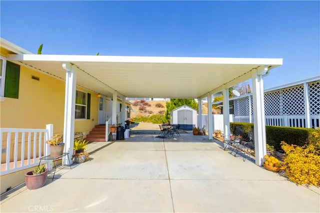 a view of a patio with table and chairs under an umbrella with a small yard