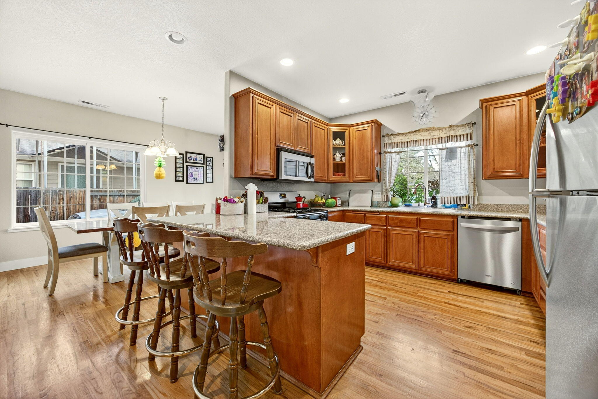 16 Portabello Way Eagle Point, OR 97524 - Photo 17 of 43 a kitchen with stainless steel appliances granite countertop wooden cabinets a dining table and chairs