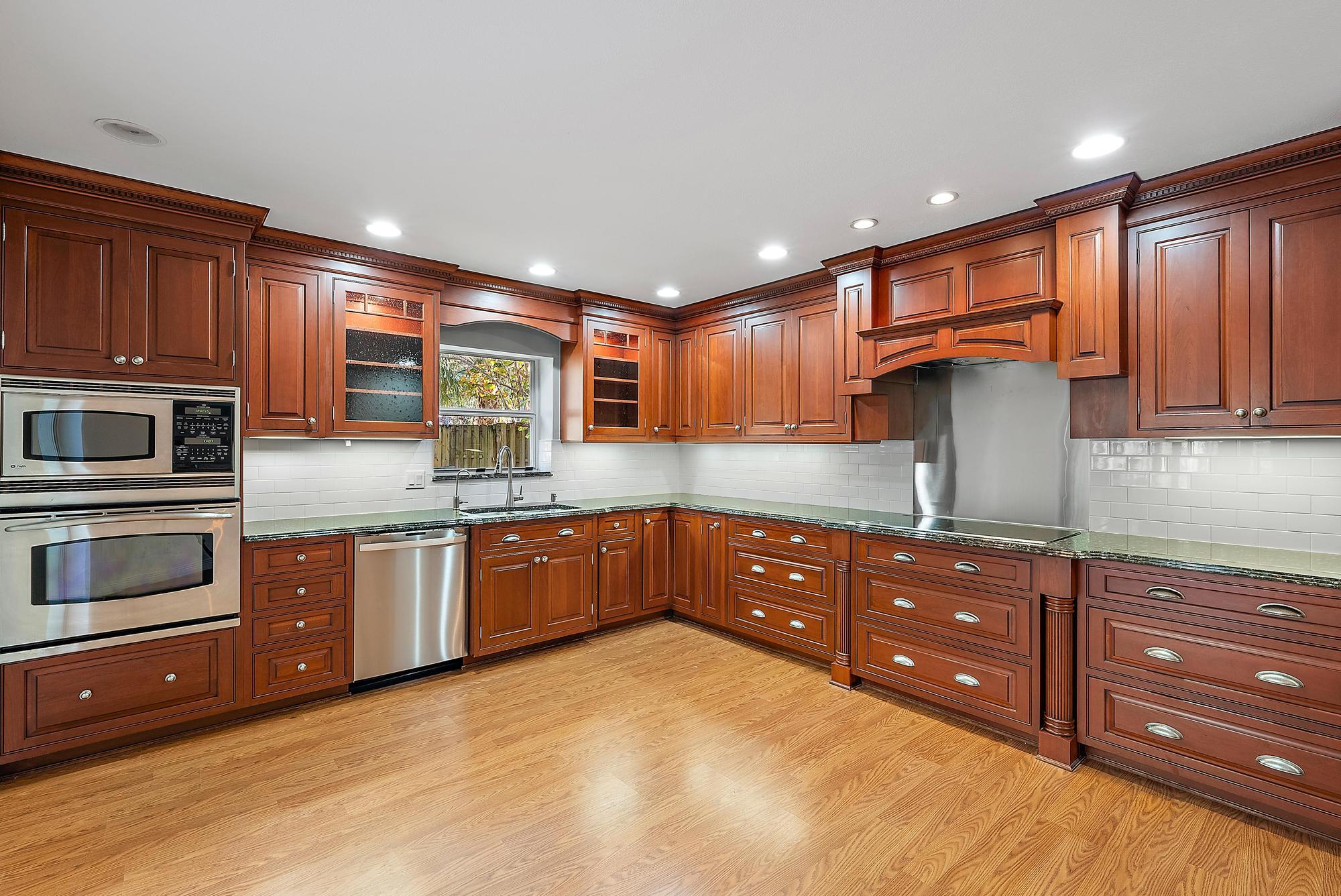 81 Southeast Beech Tree Lane Stuart, FL 34994 - Photo 11 of 27 a kitchen with stainless steel appliances granite countertop wooden cabinets and a stove top oven