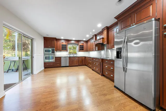 a kitchen with stainless steel appliances granite countertop a refrigerator and a sink