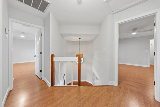 a view of a hallway with wooden floor