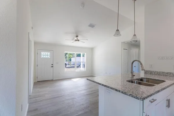 a kitchen with a sink cabinets and wooden floor