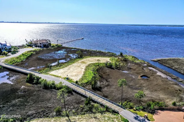 a view of a backyard with lawn chairs under an umbrella