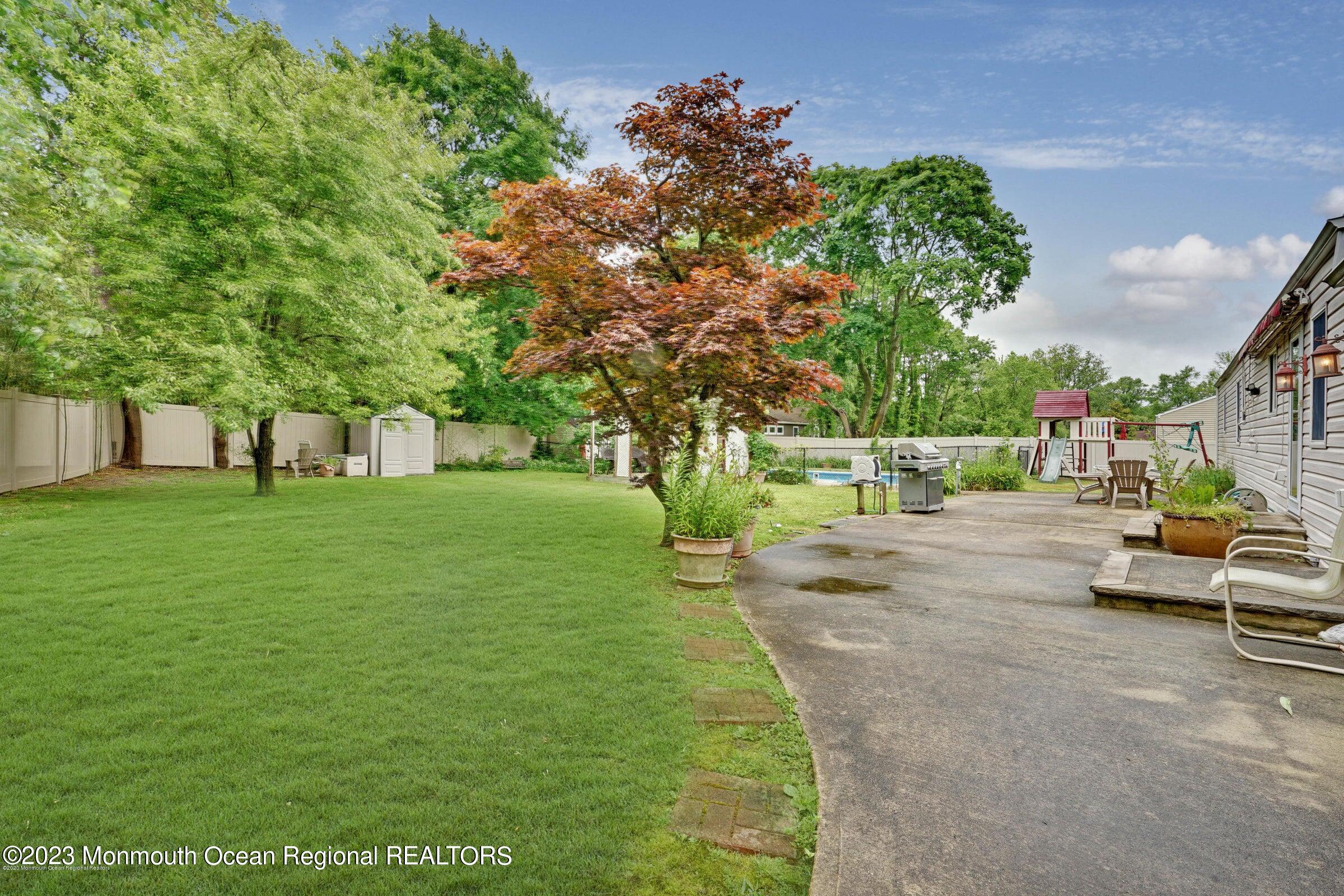 77 Pinewood Avenue West Long Branch, NJ 07764 - Photo 22 of 25 a view of yard with swimming pool and trees