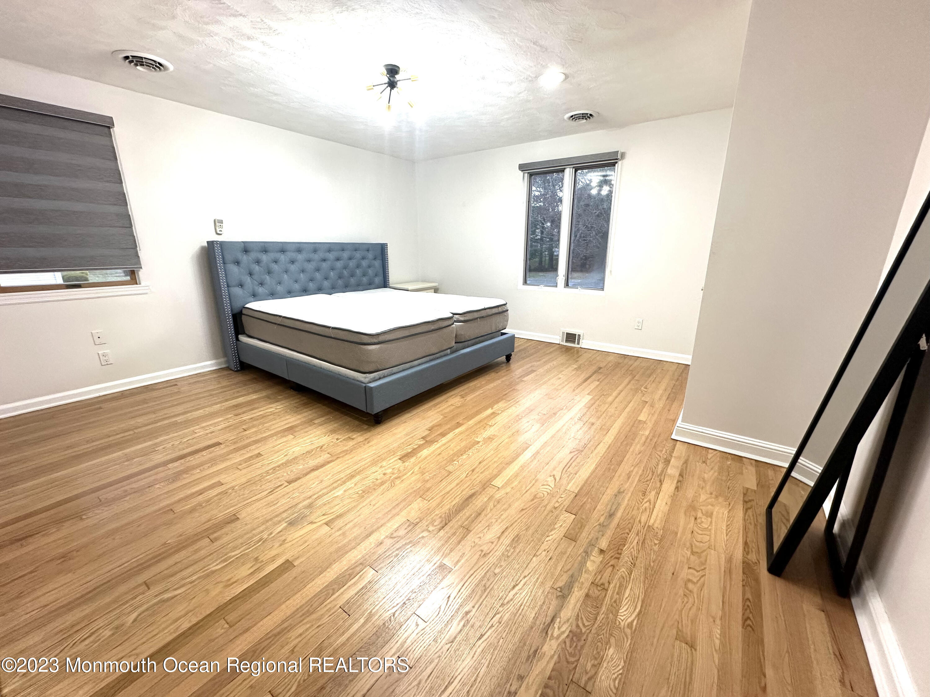 77 Pinewood Avenue West Long Branch, NJ 07764 - Photo 24 of 25 a spacious bedroom with a bed and wooden floor