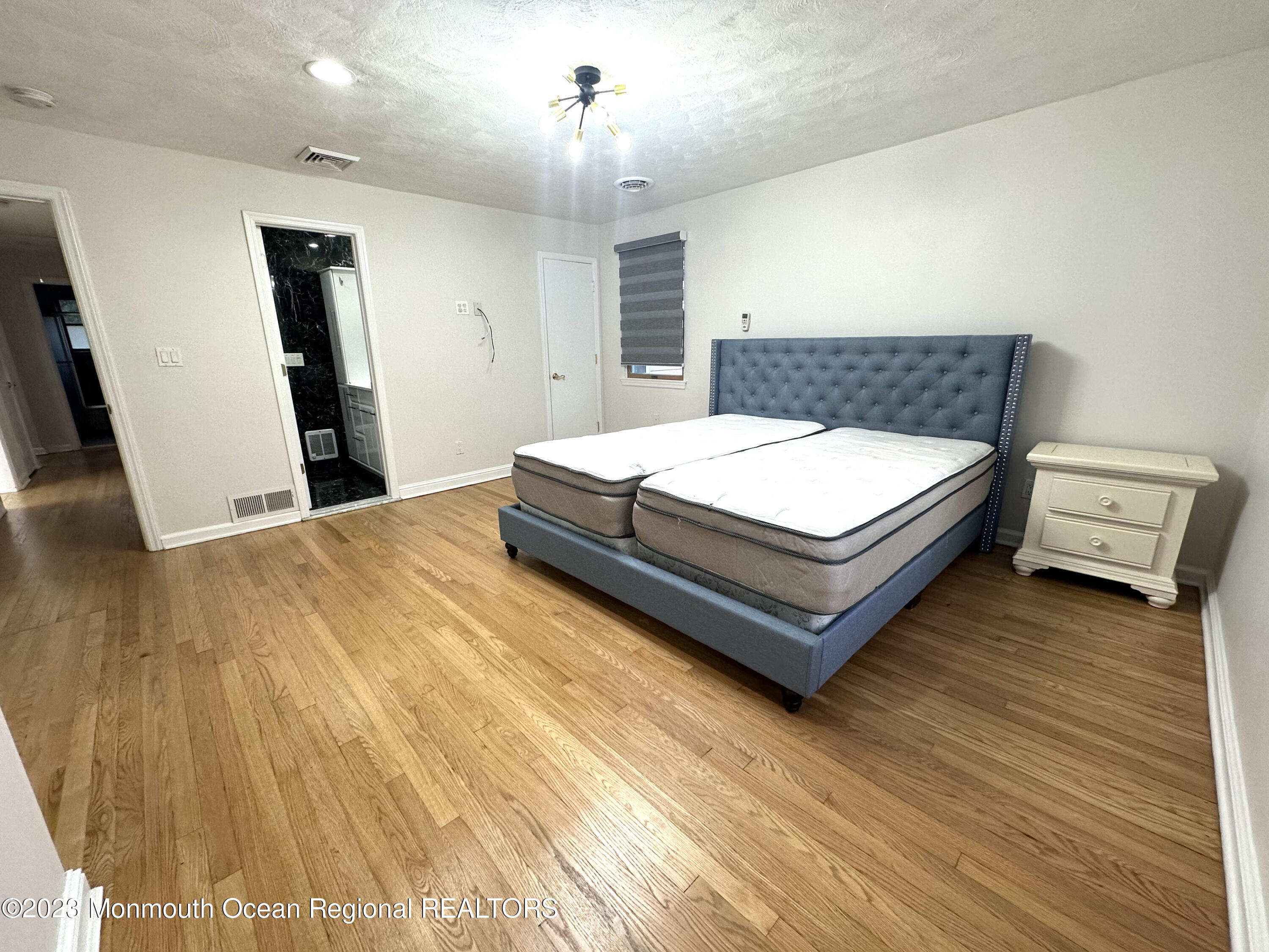 77 Pinewood Avenue West Long Branch, NJ 07764 - Photo 25 of 25 a room with a bed and a chandelier