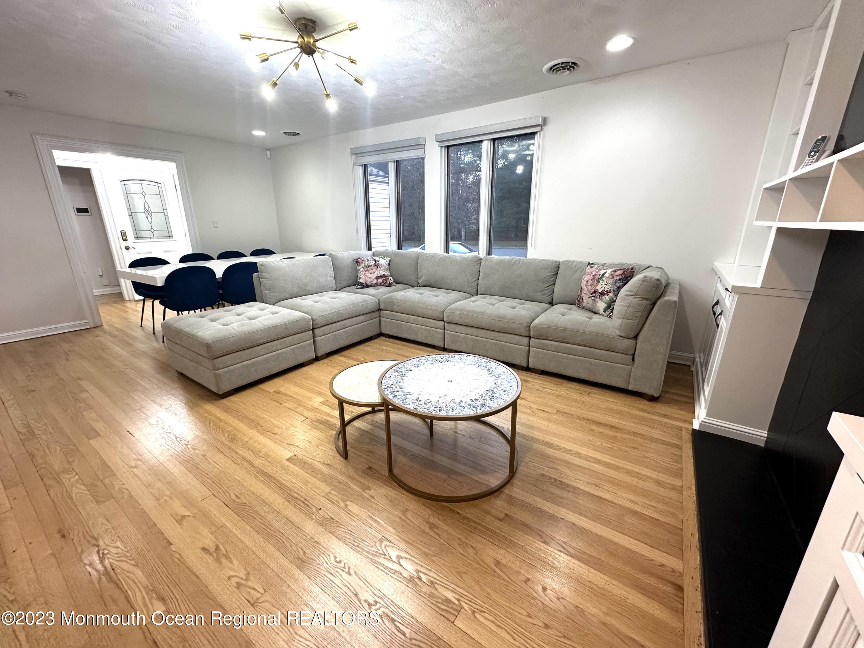 77 Pinewood Avenue West Long Branch, NJ 07764 - Photo 7 of 25 a living room with furniture and a chandelier