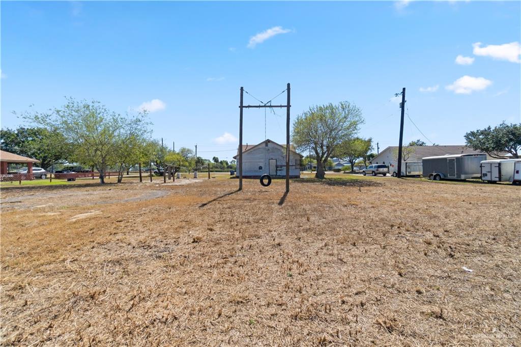 18301 Primera Road Harlingen, TX 78552 - Photo 15 of 15 a row of palm trees and a fire pit in the middle of a yard