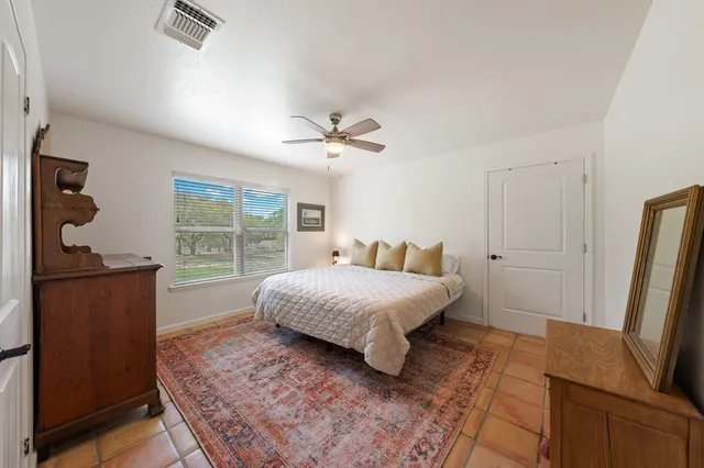a bedroom with a bed window and a dresser