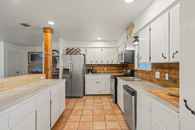 a kitchen with a sink refrigerator and microwave