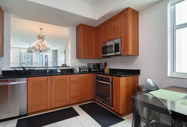 a kitchen with stainless steel appliances a stove a sink cabinets and a microwave