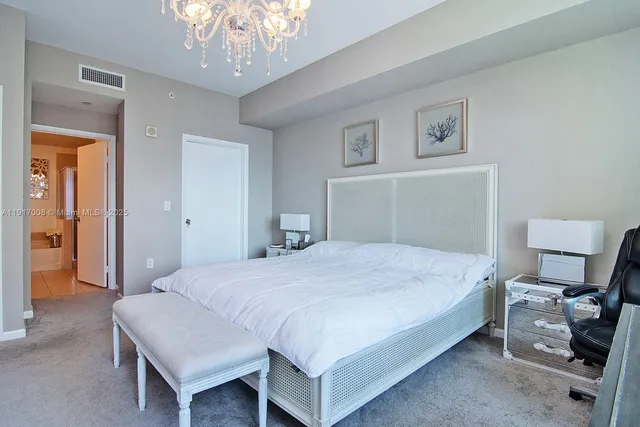 a bedroom with a bed and a chandelier
