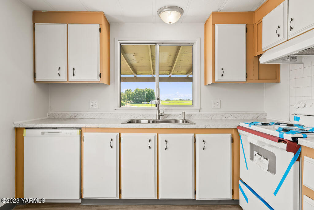 70 Albro Road Sunnyside, WA 98944 - Photo 14 of 33 a kitchen with granite countertop white cabinets and white appliances
