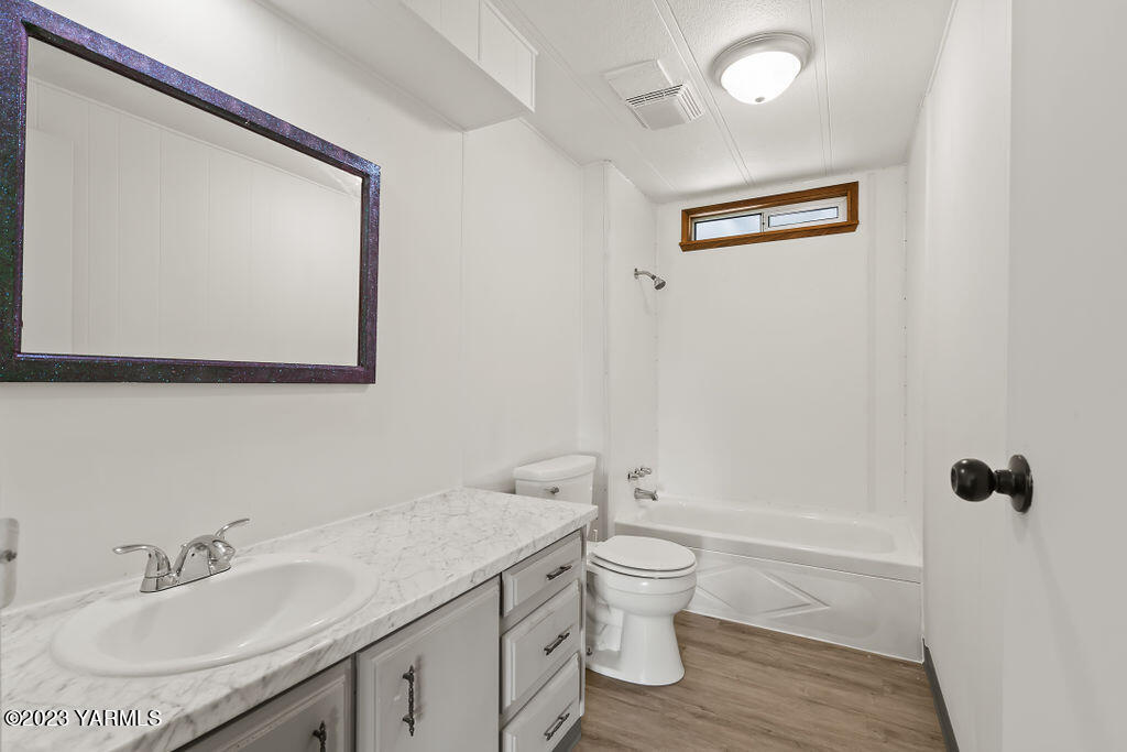 70 Albro Road Sunnyside, WA 98944 - Photo 9 of 33 a bathroom with a granite countertop sink a toilet and a bathtub