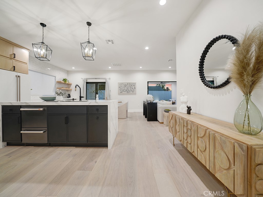 4652 Charnock Drive Irvine, CA 92604 - Photo 12 of 51 a large kitchen with stainless steel appliances kitchen island granite countertop a stove a sink a oven and a dining table with wooden floor