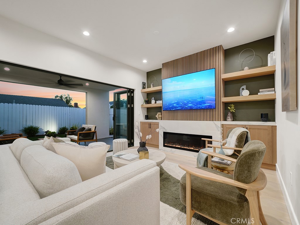 4652 Charnock Drive Irvine, CA 92604 - Photo 13 of 51 a living room with furniture a fireplace and a projector with kitchen view