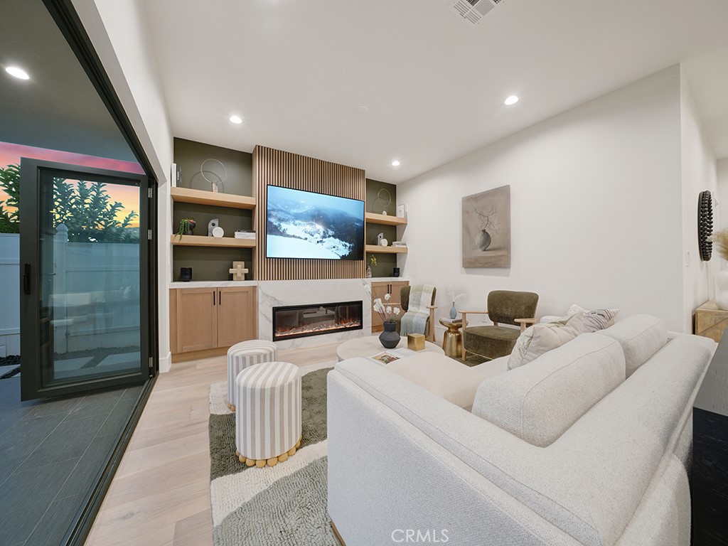 4652 Charnock Drive Irvine, CA 92604 - Photo 16 of 51 a living room with furniture a fireplace and a flat screen tv