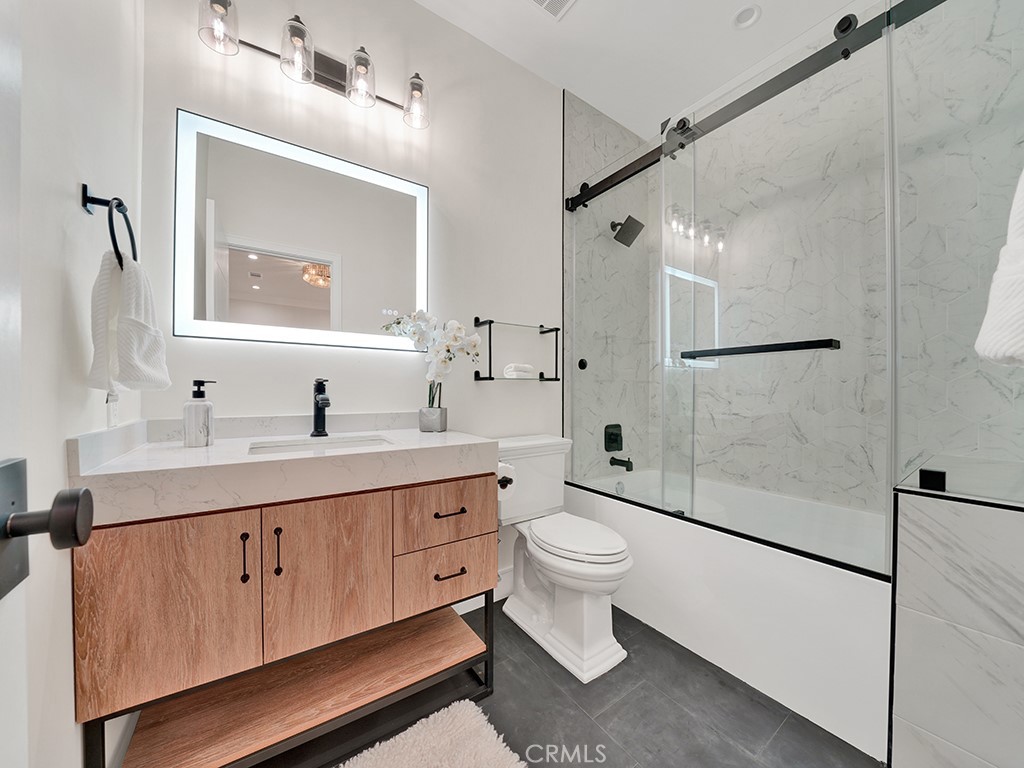 4652 Charnock Drive Irvine, CA 92604 - Photo 33 of 51 a bathroom with a toilet a sink a mirror and shower