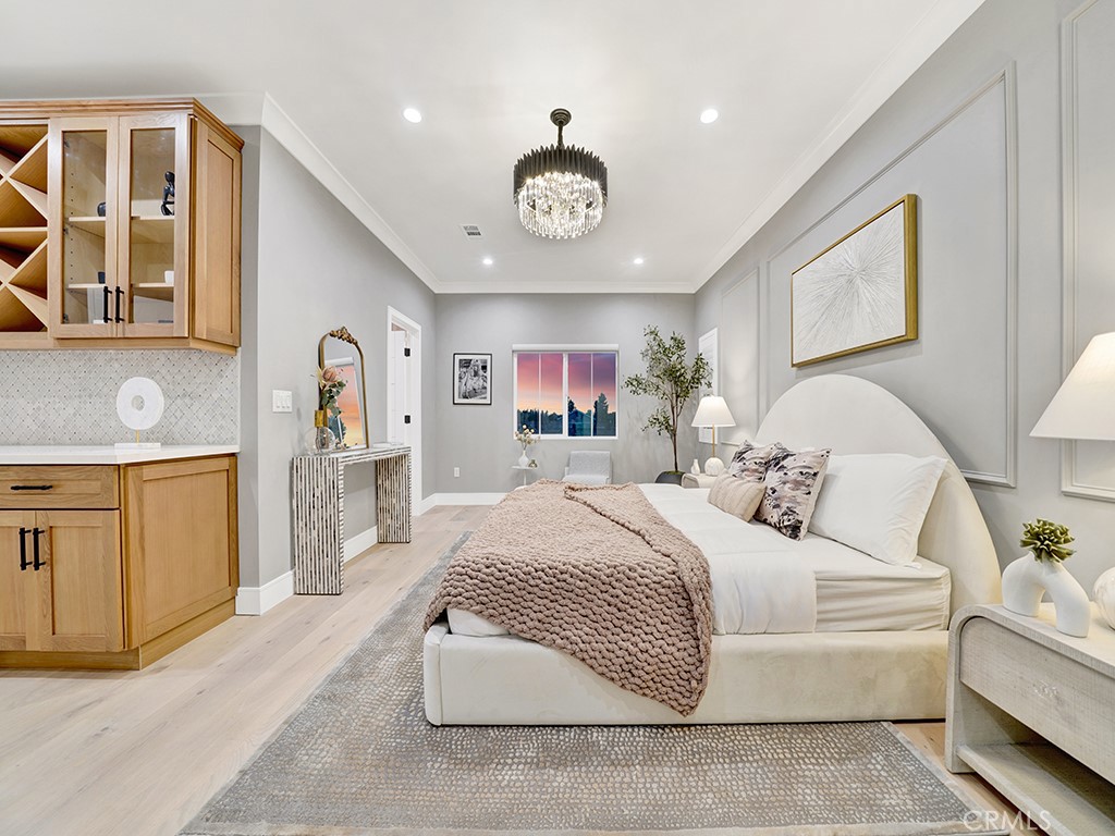 4652 Charnock Drive Irvine, CA 92604 - Photo 38 of 51 a spacious bedroom with a large bed and a chandelier