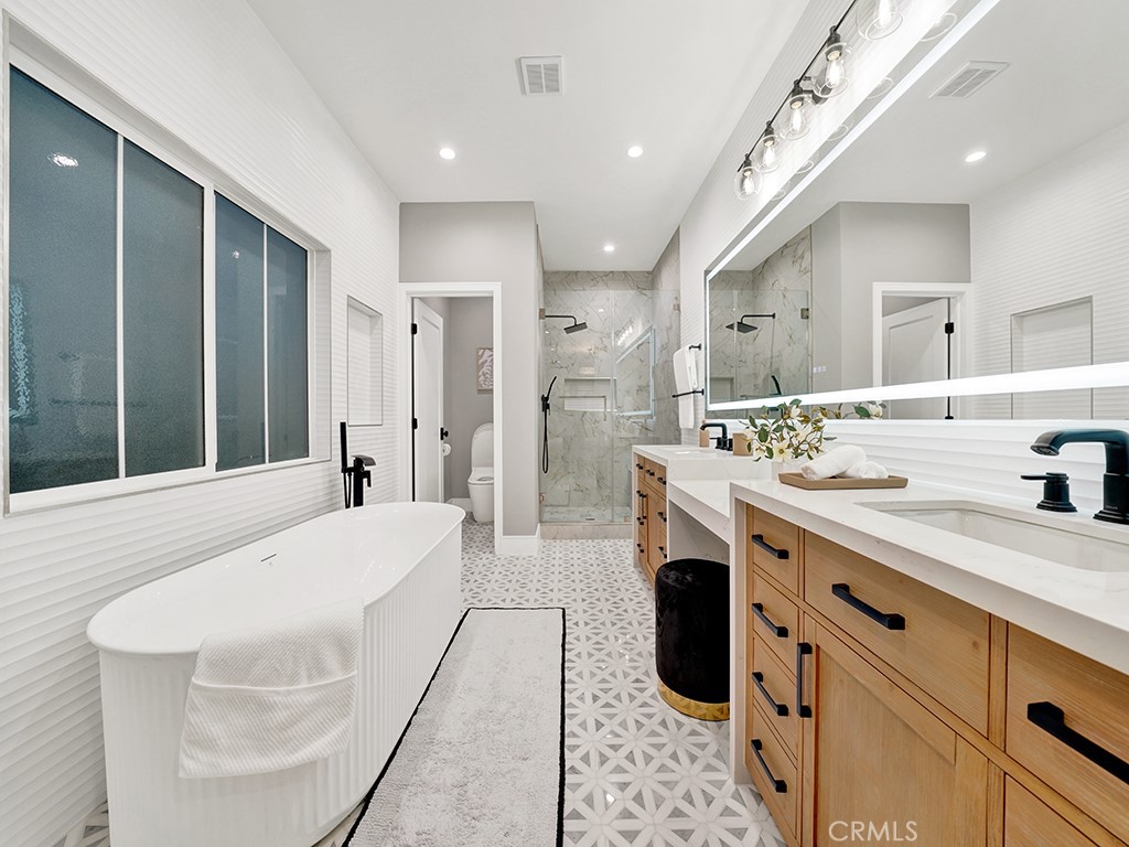 4652 Charnock Drive Irvine, CA 92604 - Photo 41 of 51 a spacious bathroom with a double vanity sink a mirror and shower