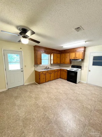 a large kitchen with cabinets and a stove top oven